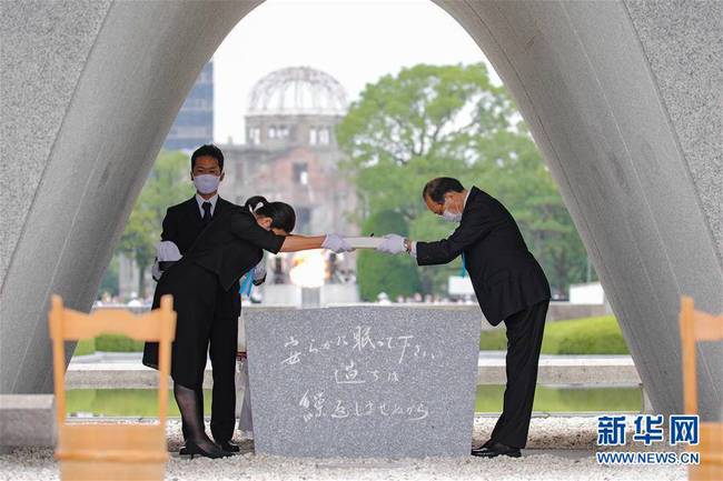 8月6日，在日本广岛，广岛市市长松井一实（右）将核爆死亡者名册安放在核爆慰灵碑内。