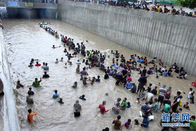 8月27日，人们在巴基斯坦卡拉奇涉水行走。
