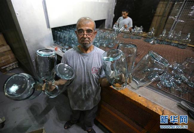 9月12日，在黎巴嫩北部城市的黎波里，一家玻璃制品厂的工人展示烧制完的玻璃制品。