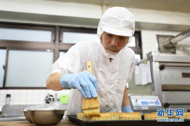 9月30日，在日本横滨，菜香食品公司的工作人员在制作月饼。