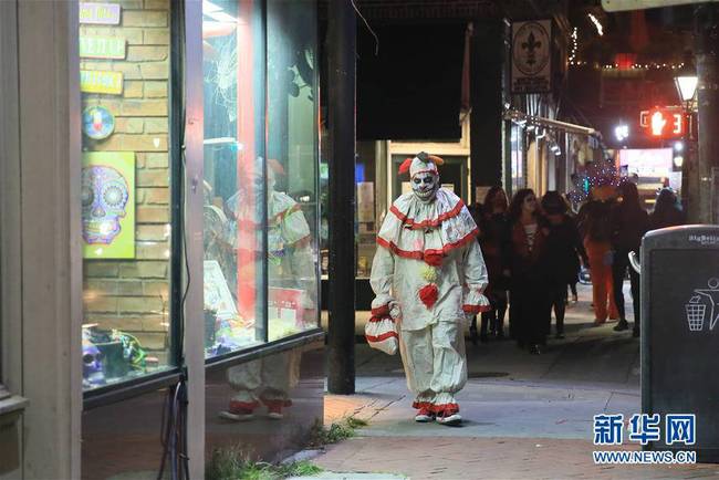 10月31日，在美国路易斯安那州新奥尔良，一名打扮成小丑的男子在街头庆祝万圣夜。 