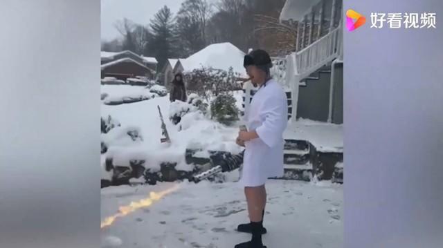 美国一男子用喷火器清除门前积雪，身穿浴袍手拿啤酒口叼雪茄