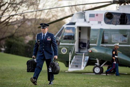 美国军官手提“核足球”，身后是美国总统专机。