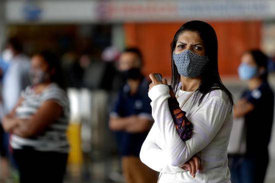  2020年12月23日，在巴西首都巴西利亚中央车站，一名女子戴着口罩等车。新华社发（卢西奥·塔沃拉摄）