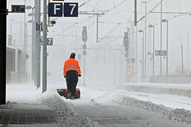 △德国遭遇罕见暴风雪天气，工人正在铁路站台清除积雪（图片来源：德新社）