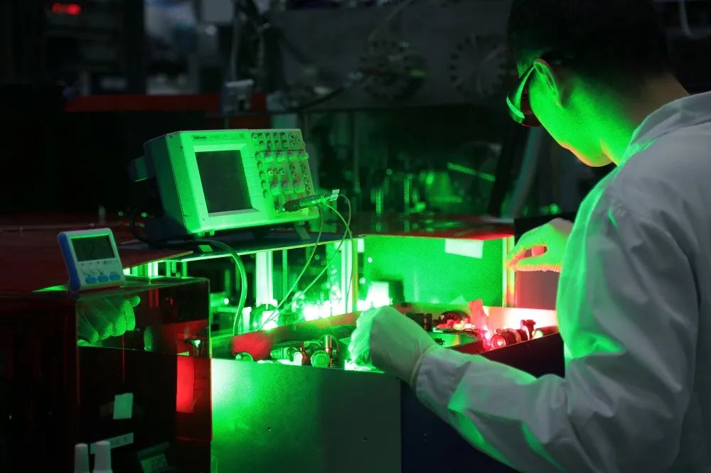研究人员在控制氢分子化学键取向的激光器前工作。图片来源：中科院大连化物所