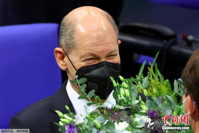 当地时间12月8日，德国联邦议院正式选举社民党总理候选人朔尔茨为新一届德国总理。图为朔尔茨收到鲜花。
